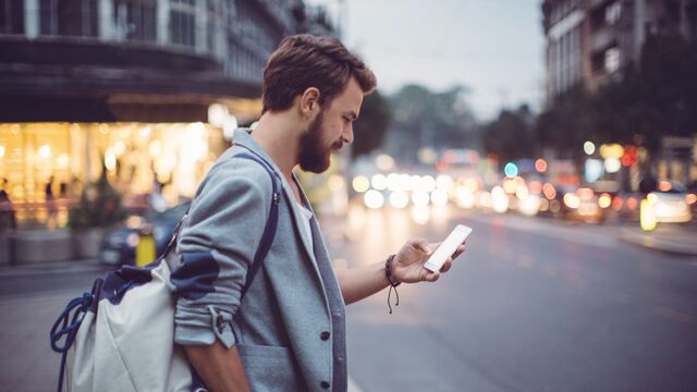 Man checking mobile on a street - SMALL